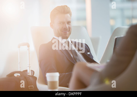 Businessman smiling in airport Stock Photo