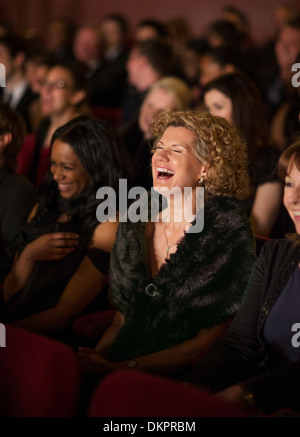 Woman laughing enthusiastically in theater audience Stock Photo