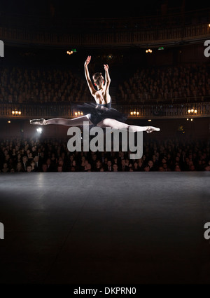 Ballerina mid-air on theater stage Stock Photo
