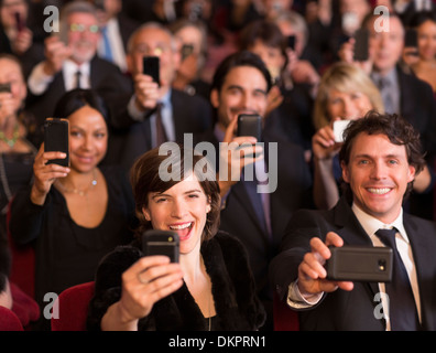 Enthusiastic theater audience videoing performance with smart phones Stock Photo