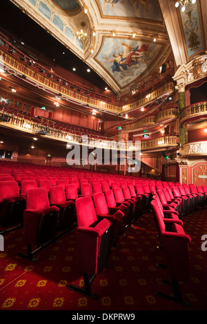 Balconies, seats and ornate ceiling in empty theater auditorium Stock Photo