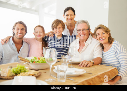 Multi-generation family smiling together at table Stock Photo
