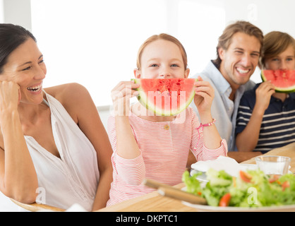 Family eating watermelon at table Stock Photo