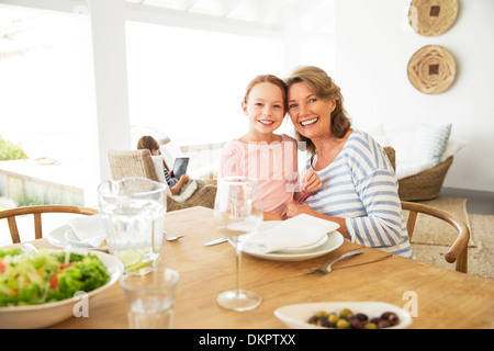 Older woman and granddaughter smiling at table Stock Photo