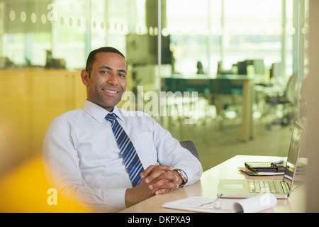 Businessman smiling at desk Stock Photo