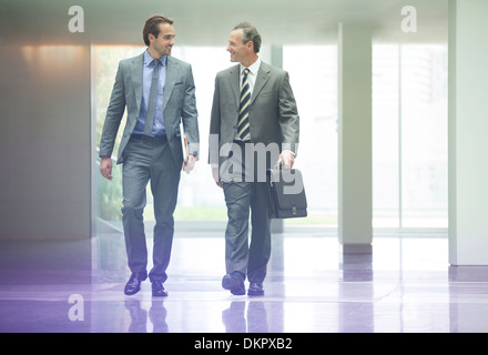 Businessmen talking in office lobby Stock Photo - Alamy
