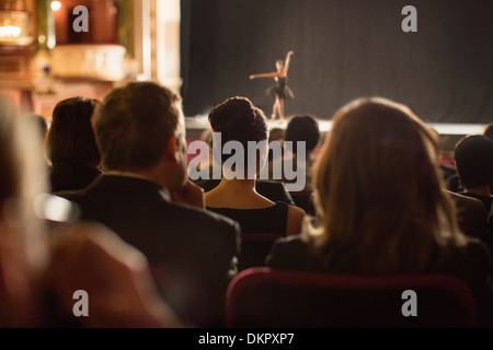 Rear view of theater audience watching performers on stage Stock Photo