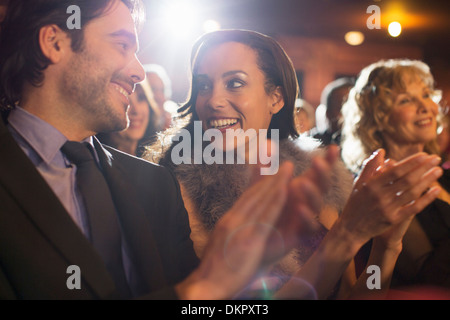 Close up of couple clapping in theater Stock Photo