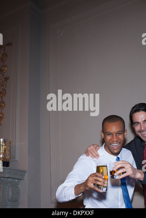 Portrait of well dressed men toasting beer and cocktail Stock Photo
