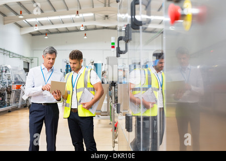 Supervisor and worker using digital tablet in factory Stock Photo