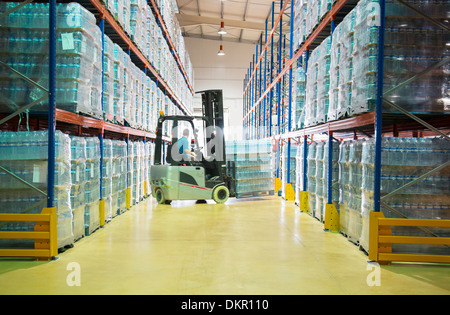 Worker moving pallets with forklift in warehouse Stock Photo