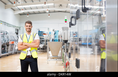 Worker smiling in factory Stock Photo