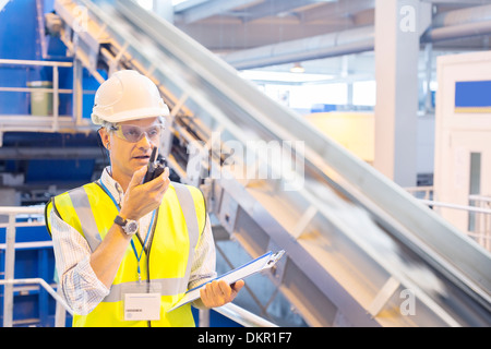 Supervisor using walkie-talkie in recycling center Stock Photo