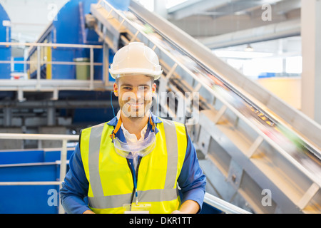 Worker smiling in recycling center Stock Photo
