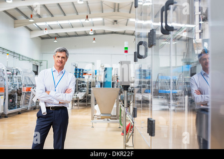 Businessman smiling in factory Stock Photo