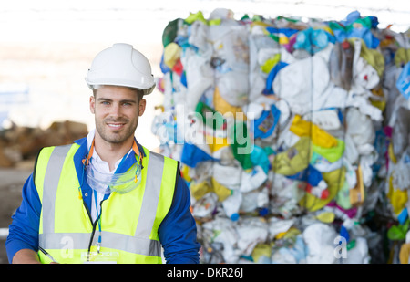 Worker smiling in recycling center Stock Photo