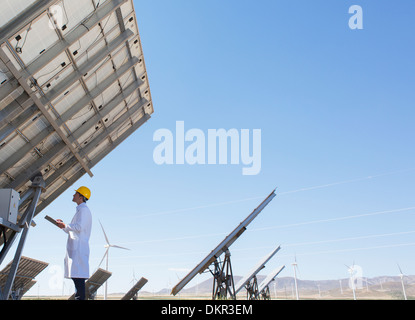 Scientist examining solar panel in rural landscape Stock Photo