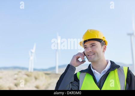 Worker using walkie talkie in rural landscape Stock Photo