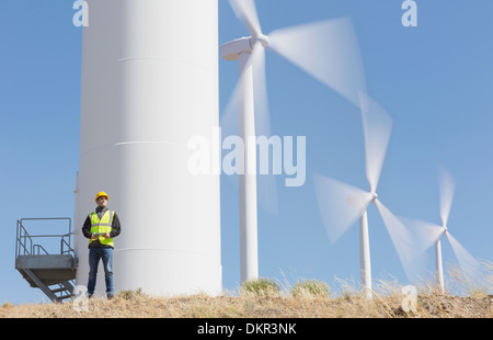 Worker by wind turbines in rural landscape Stock Photo