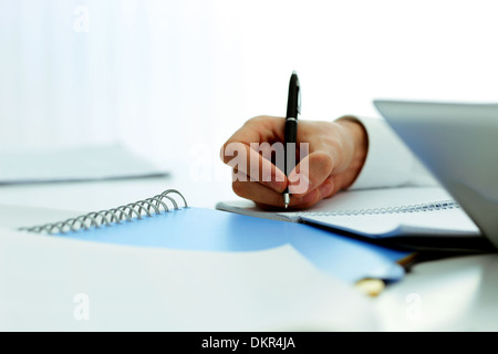 Closeup image of mans hand writing in notebook Stock Photo