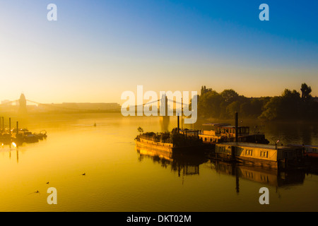 Houseboats and barges reflecting the sunrise on a slightly misty day in Hammersmith, West London. Stock Photo