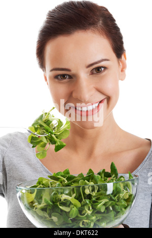 Young casual woman eating lamb's lettuce. Isolated on white.  Stock Photo