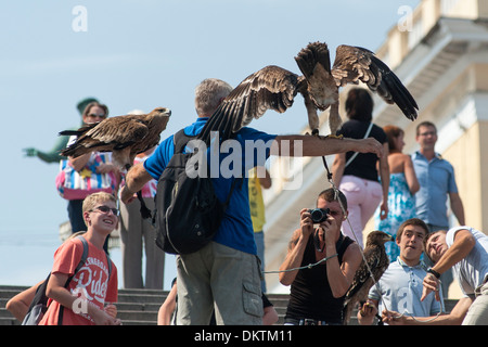 Hustlers on the Potemkin Stairs in Odessa selling tourists the opportunity to have a photograph taken with an eagle. Stock Photo