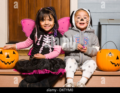 Young children dressed in costume for Halloween Trick-or-Treating Stock Photo