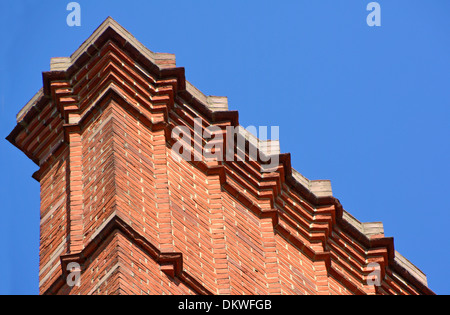 Elaborate brick corbelling below (out of view) flue pots at top of large chimney stack London England UK Stock Photo