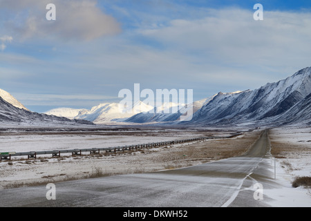 Snowy Dalton Highway and Alyeska oil pipeline in the Brooks Range mountains of Alaska USA Stock Photo