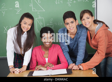 Teacher With High School Students At Desk Stock Photo