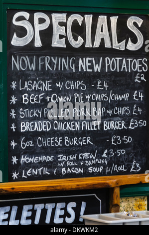 Blackboard at a "greasy spoon" type cafe serving chips, lasagne, beef and onion pie, burgers, Irish stew and other food. Stock Photo
