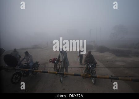 Haryana, India. 10th Dec, 2013. Local people wait to pass a railway crossing on a foggy day in a village near the city of Jind, Haryana, India, Dec. 10, 2013. Heavy fog cloaked many places in north India's states of Haryana and Punjab, with visibility less then 200 meters in some areas, affecting public transportation and local people's life. Credit:  Zheng Huansong/Xinhua/Alamy Live News Stock Photo