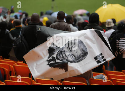 Johannesburg, South Africa. 10th Dec, 2013. People hold a portrait of Nelson Mandela before the memorial service for the former South African president at the FNB Stadium in Soweto near Johannesburg, South Africa, Dec. 10, 2013. Credit:  Zhang Chen/Xinhua/Alamy Live News Stock Photo