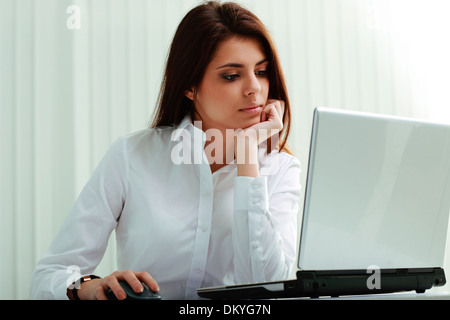 Young businesswoman in headphones working on a laptop at office Stock Photo