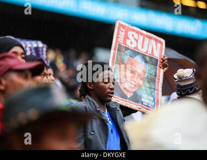 Johannesburg, South Africa. 10th Dec, 2013. People hold a poster of Nelson Mandela before the memorial service for the former South African president at the FNB Stadium in Soweto near Johannesburg, South Africa, Dec. 10, 2013. Credit:  Meng Chenguang/Xinhua/Alamy Live News Stock Photo