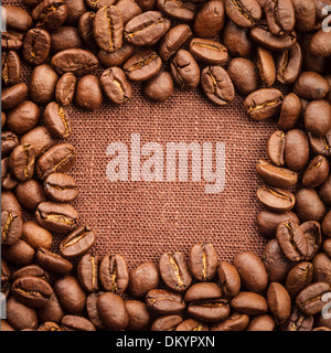 Spilled coffee beans frame over linen textile Stock Photo