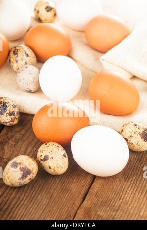 Eggs on textile tablecloth over rustic wooden table Stock Photo