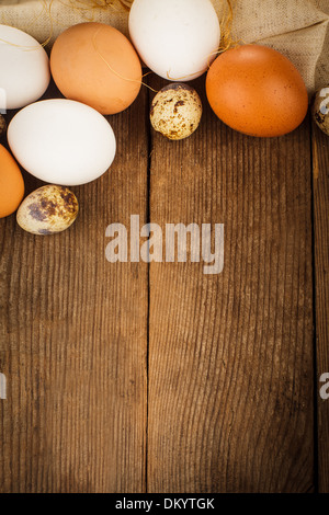 Eggs on textile tablecloth over rustic wooden table with copyspace Stock Photo