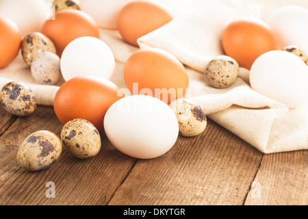 Eggs on textile tablecloth over rustic wooden table Stock Photo