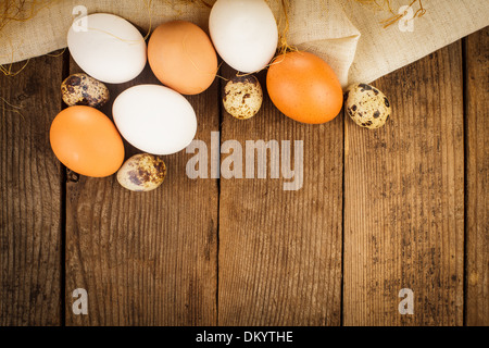 Eggs on textile tablecloth over rustic wooden table with copyspace Stock Photo
