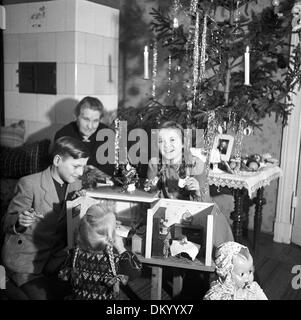 A grandmother happily watches her grandchildren play with the presents they got for Christmas in Berlin, Germany, in 1949. Photo: Eva Richter Stock Photo