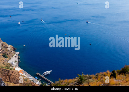 Beautiful waters of bay near Fira in Santorini, Greece with boats in the sea Stock Photo