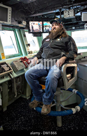 Duck Dynasty reality television star Willie Robertson sits in the commanding officer's chair during a tour of the bridge aboard the Arleigh Burke-class guided-missile destroyer USS Stout December 7, 2013 in Souda Bay, Greece. Robertson's visit is part of the annual USO holiday tour to help boost the moral of service members deployed overseas. Stock Photo