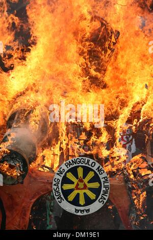 Manila, Philippines. 10th Dec, 2013. The presidential insignia being burned along with President Aquino III's effigy, during the International Human Rights Day protest in Mendiola, Manila. -- Protesters commemorated the International Human Rights Day with a march to Mendiola, Manila bringing effigies of President Aquino III. They dubbed Aquino as the ''impunity king'' for alleged human rights violations since he started his term.Photo: J Gerard Seguia/NurPhoto Credit:  J Gerard Seguia/NurPhoto/ZUMAPRESS.com/Alamy Live News Stock Photo