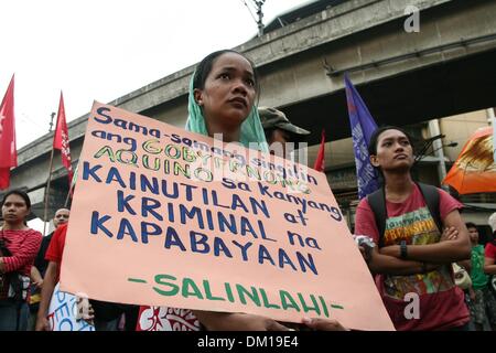 Manila, Philippines. 10th Dec, 2013. Sanlinlahi member holding a poster condemning President Aquino III's alleged incompetence over the country's current situation. -- Protesters commemorated the International Human Rights Day with a march to Mendiola, Manila bringing effigies of President Aquino III. They dubbed Aquino as the ''impunity king'' for alleged human rights violations since he started his term.Photo: J Gerard Seguia/NurPhoto Credit:  J Gerard Seguia/NurPhoto/ZUMAPRESS.com/Alamy Live News Stock Photo