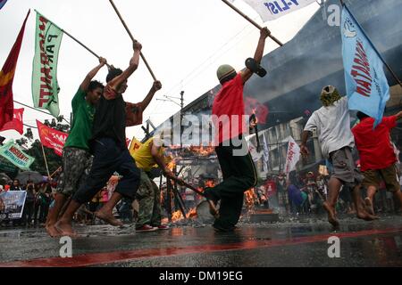 Manila, Philippines. 10th Dec, 2013. Protesters running around the burnt effigy of President Aquino III in Mendiola, Manila. -- Protesters commemorated the International Human Rights Day with a march to Mendiola, Manila bringing effigies of President Aquino III. They dubbed Aquino as the ''impunity king'' for alleged human rights violations since he started his term.Photo: J Gerard Seguia/NurPhoto Credit:  J Gerard Seguia/NurPhoto/ZUMAPRESS.com/Alamy Live News Stock Photo