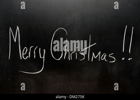 Close up of a blackboard with Merry Christmas written on it in chalk. Stock Photo