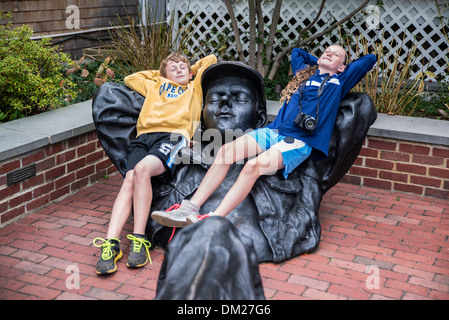 Siblings relax with a sculpture, Edgartown, Martha's Vineyard, Massachusetts, USA Stock Photo