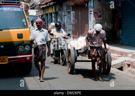 An Indian man with a heavy hand cart Stock Photo